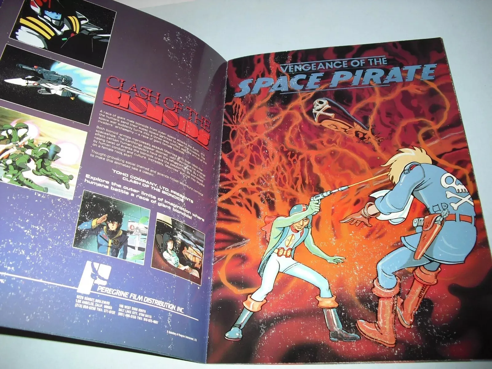 Photo of an open catalogue spread: Clash of the Bionoids copy and stills on the left, Vengeance of the Space Pirate art on the right