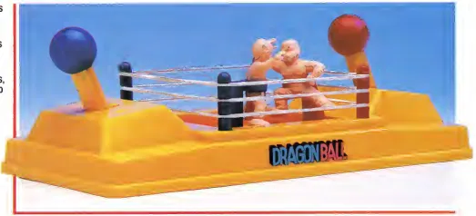 Detail of the yellow Dragon Ball ring, with two unpainted figures between the ropes and blue and red ball-topped controls at opposite ends.