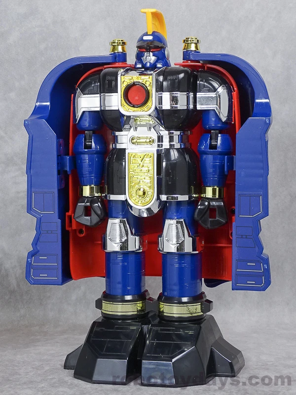 Original Japanese Bandai DX Gunmazin toy in warrior form, with its red-lined blue shell open, gold crest raised and black feet planted beneath silver knees.