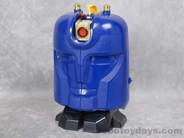Original DX Gunmazin toy folded into its large blue smiling face above black feet, photographed from a three-quarter angle.