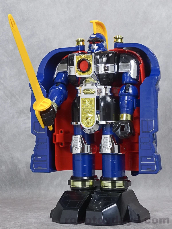 The original DX Gunmazin toy standing in warrior form with its blue shell open and a long yellow-bladed saber raised in one hand.