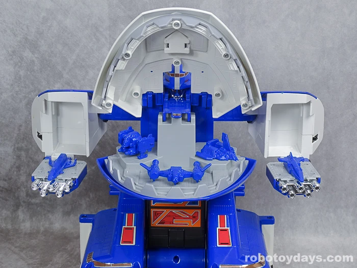 Original GigaBitus toy with its mouth and both arm hangars open to reveal five blue miniature aircraft.