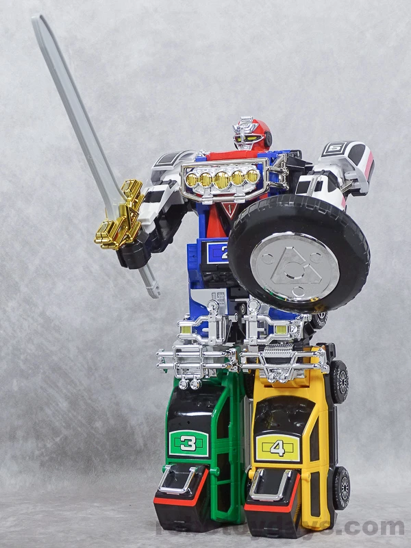 Original Japanese DX RV Robo holding a silver sword with a gold guard and a black tire-shaped shield.