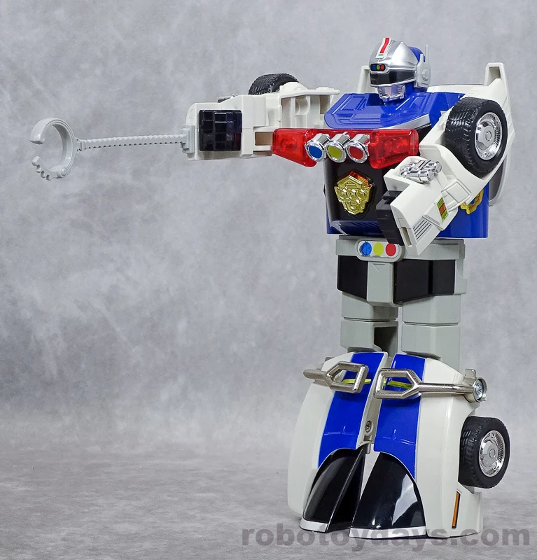 Original DX Sirender aiming a silver handcuff accessory on a molded chain from its right forearm.