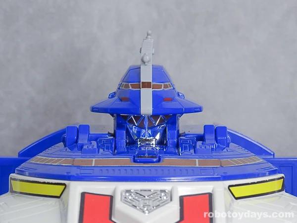 Close photograph of the original GigaBitus toy’s blue bridge-shaped head with silver face.