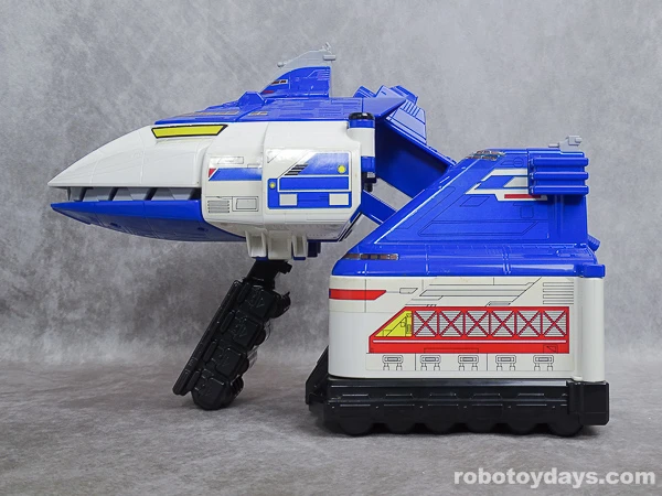 Side view of the original toy during transformation, with the front hull lifted and the wheel support angled down.